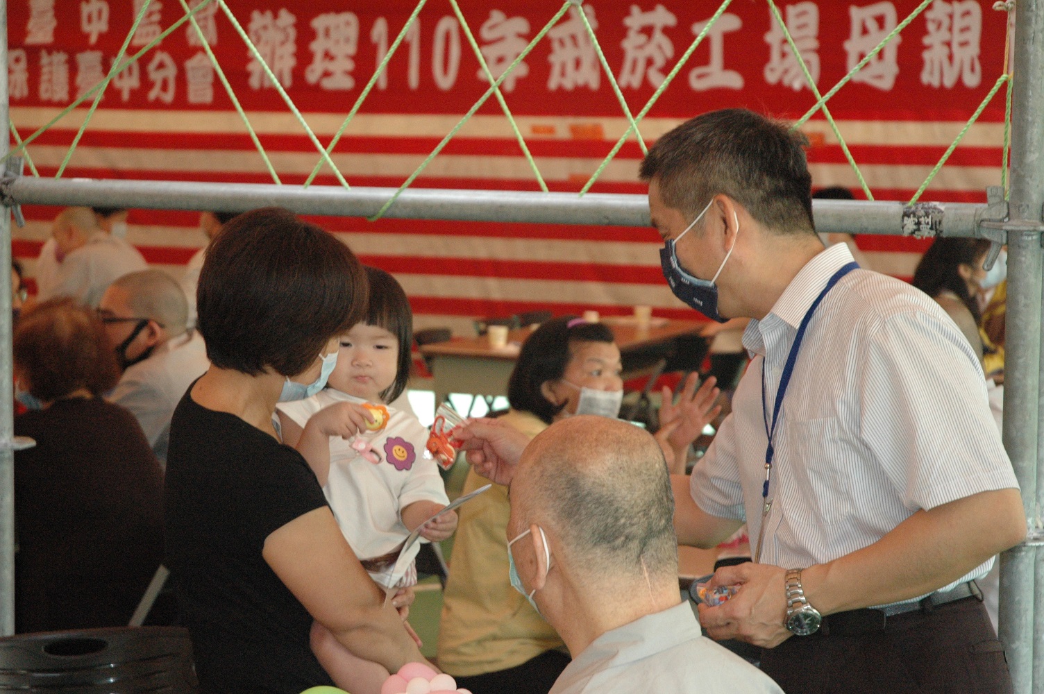 秘書蒞臨懇親會場發放捏麵人卡通吊飾給參加之兒童