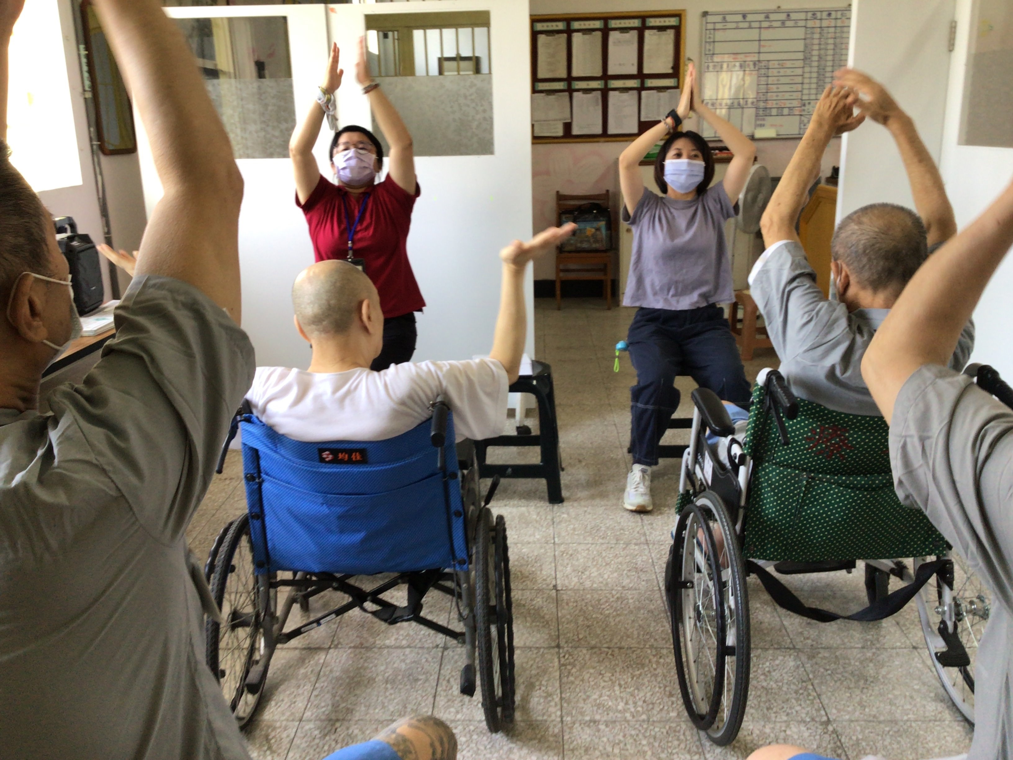 Elderly inmates followed instructors to do yoga on their chairs.