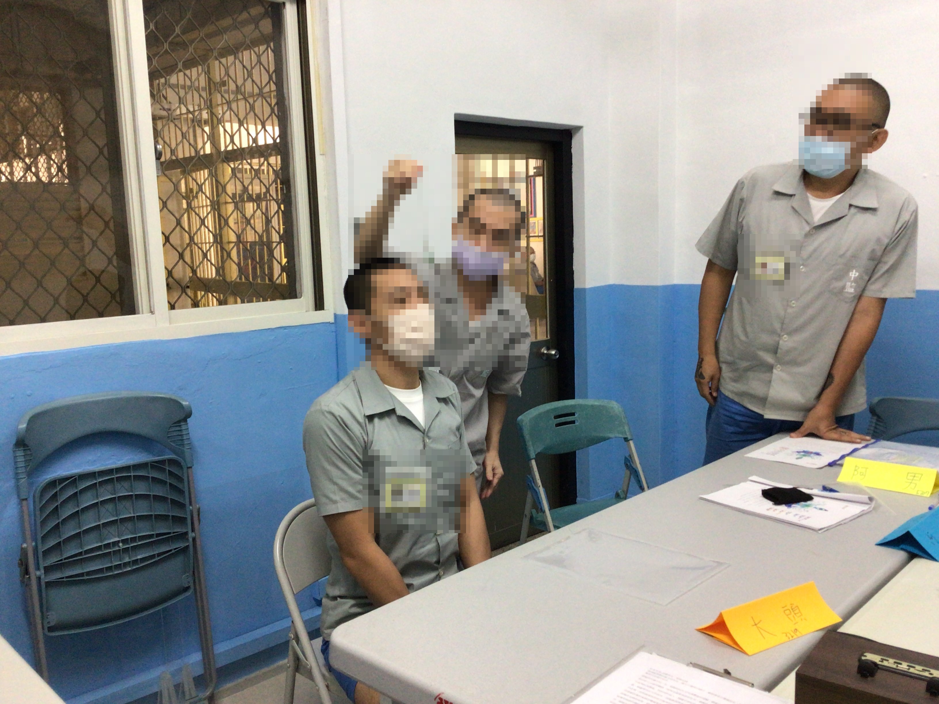 An inmate uses a pendulum to check the status of another inmate’s chakras.