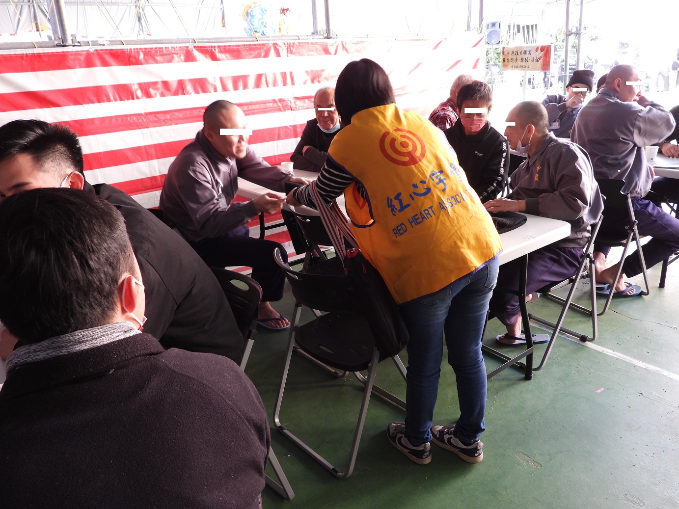 A volunteer distributes brochures about social care resources to the attendees at the reunion activity.